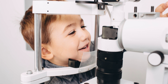 Young boy smiling during an eye exam at Moorfields Eye Hospital