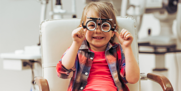 Smiling young patient sitting in a comfortable chair wearing test glasses at Moorfields Eye Hospitals