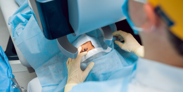 patient on surgical bed with surgeon performing precise eye surgery using laser technology