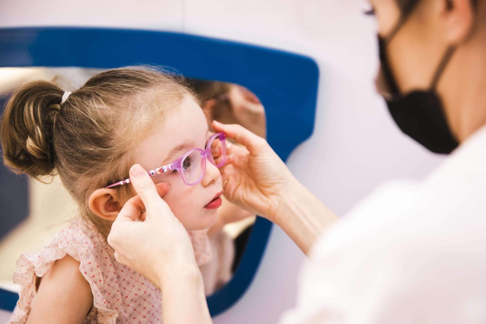 Young girl trying eyeglass frames at Moorfields Dubai optical shop